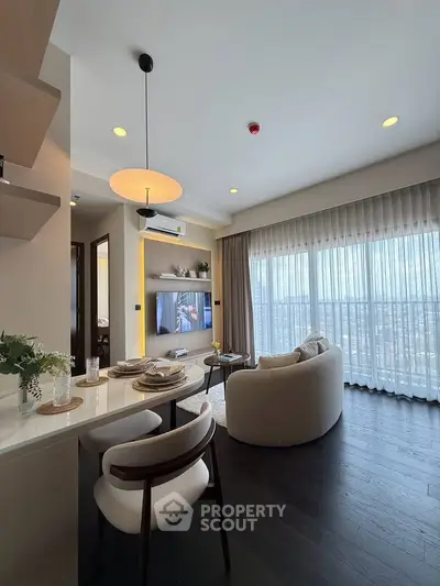 Modern living room with elegant decor and large windows offering stunning city views.