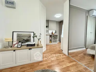 Modern living room with stylish decor and wooden flooring, featuring a cozy ambiance and ample natural light.