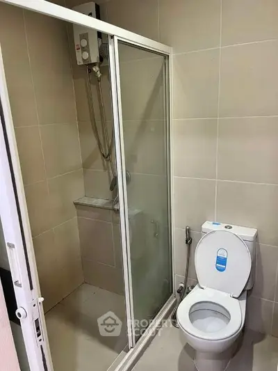 Modern bathroom with glass shower enclosure and sleek toilet design.