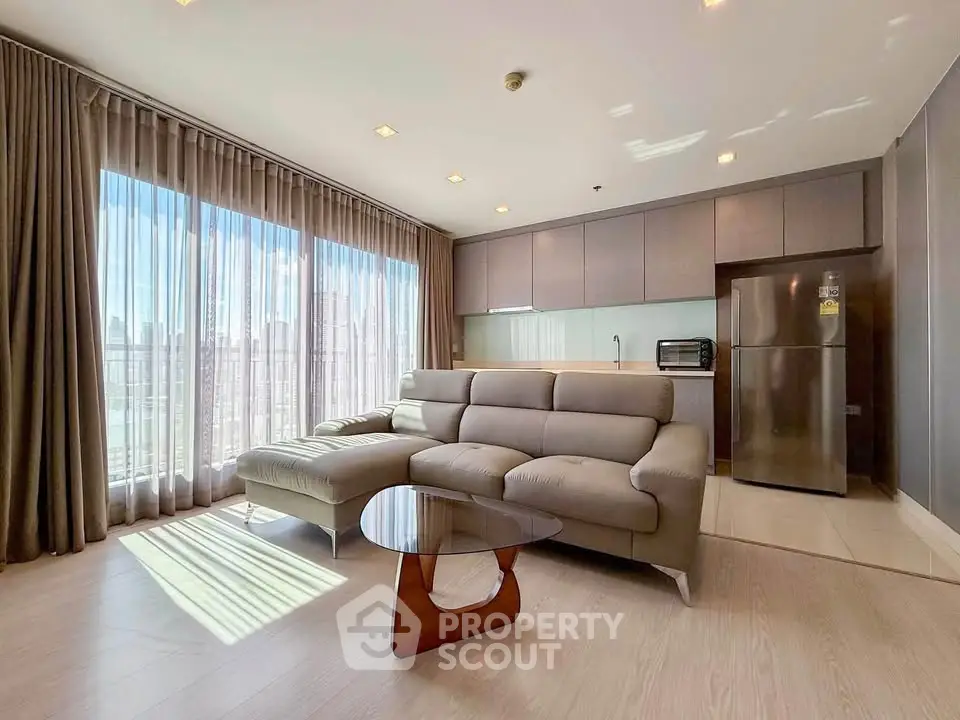 Spacious modern living room with large windows and stylish furniture in a high-rise apartment.