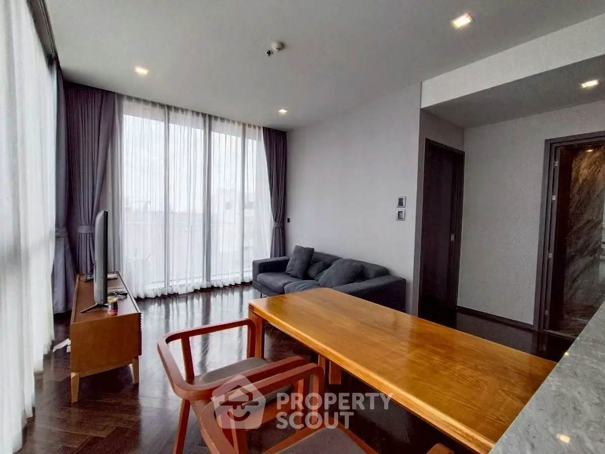 Spacious modern living room with large windows and elegant wooden furniture