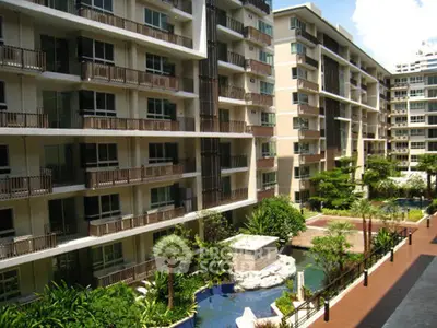 Modern apartment complex with lush gardens and water features, offering a serene urban living experience.