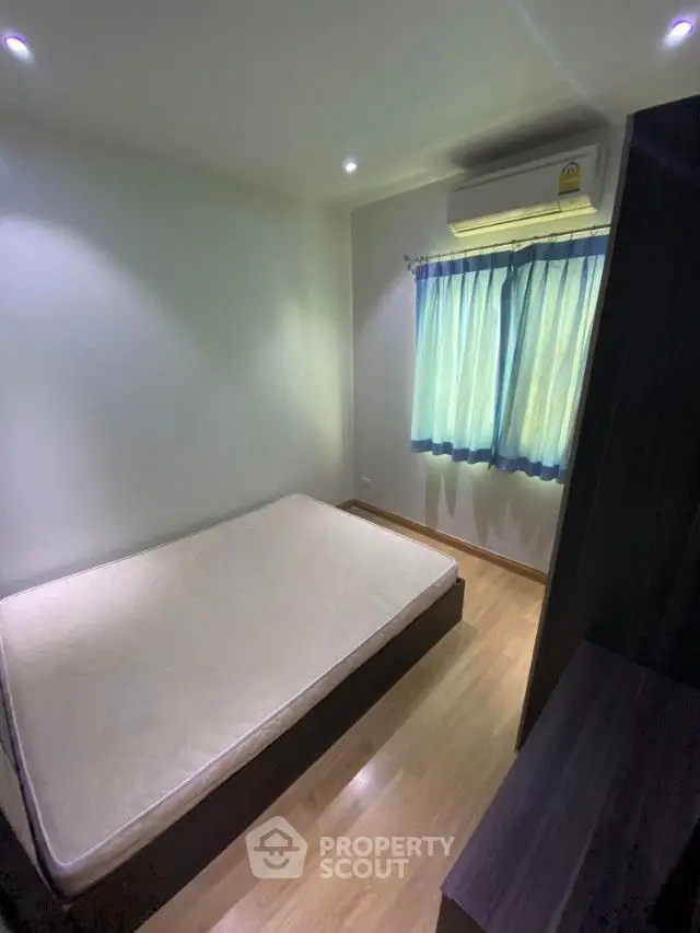 Cozy bedroom with ample natural light, featuring a large bed, wooden flooring, and a serene ambiance perfect for relaxation.