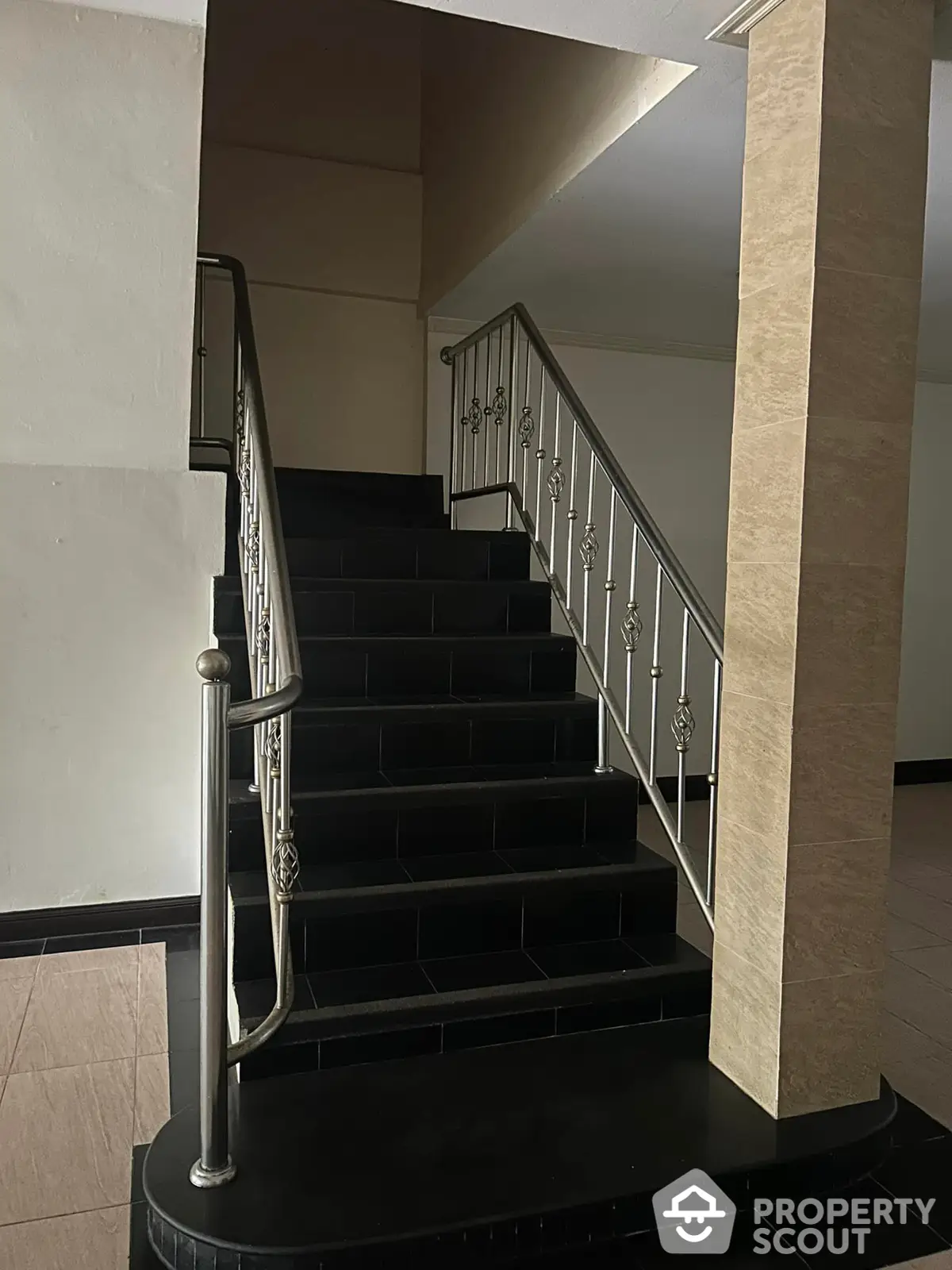 Elegant staircase with black steps and stylish metal railings, enhancing the modern aesthetic of a luxurious property's interior.