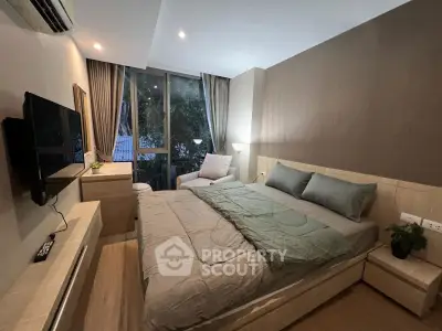 Modern bedroom with cozy decor and large window offering natural light