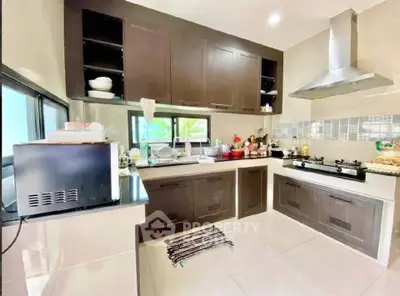 Modern kitchen with dark wood cabinets and sleek appliances