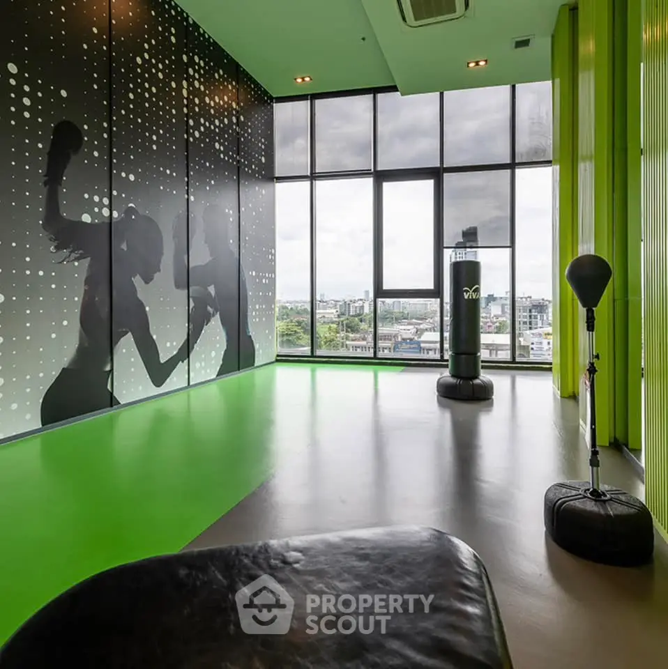 Modern gym with city view and boxing equipment in high-rise building
