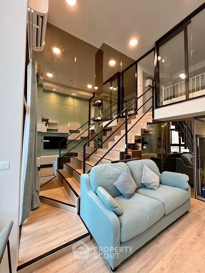 Modern duplex living room with stylish staircase and cozy sofa