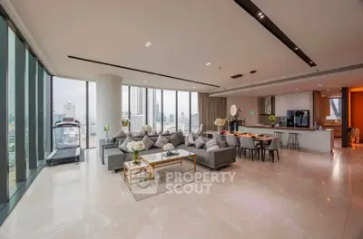 Luxurious open-plan living room with panoramic city views and modern furnishings in a high-rise apartment.
