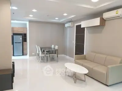 Modern living room with sleek furniture and dining area in open layout.