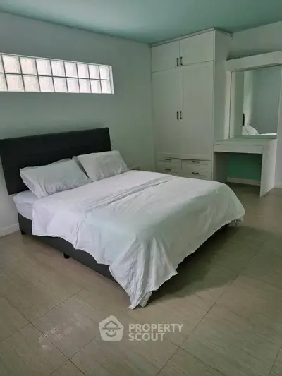 Spacious bedroom with modern furnishings and ample natural light