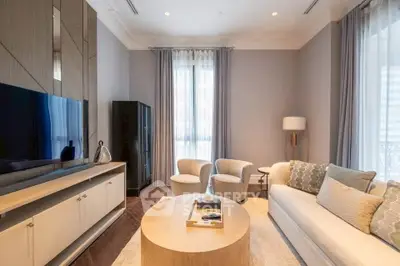 Elegant living room with modern furniture and large TV, perfect for relaxation and entertainment.