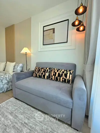 Stylish living room with modern decor and cozy seating area, featuring elegant lighting and contemporary artwork.