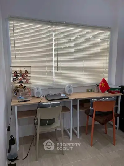 Modern study room with dual desks and window blinds, perfect for productivity.
