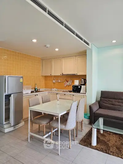 Modern kitchen and dining area with sleek appliances and cozy seating.