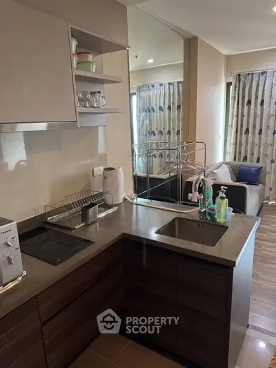Modern kitchen with sleek design and open layout leading to cozy living area.