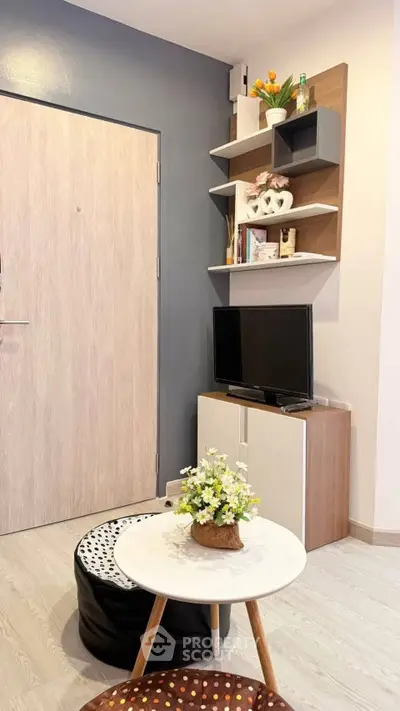Modern living room with stylish decor and compact TV setup, perfect for cozy urban living.