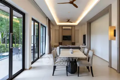 Luxurious open-plan living and dining area with pool view and modern decor.