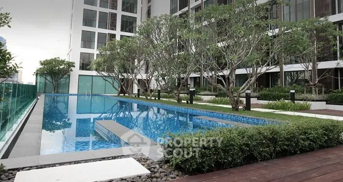 Luxurious apartment complex with a stunning outdoor pool and lush greenery.