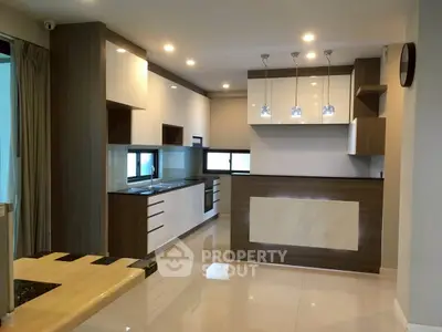 Modern kitchen with sleek cabinetry and stylish lighting in a contemporary home.