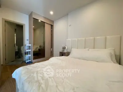 Spacious bedroom with modern design and ample natural light, featuring a large bed and built-in wardrobe.
