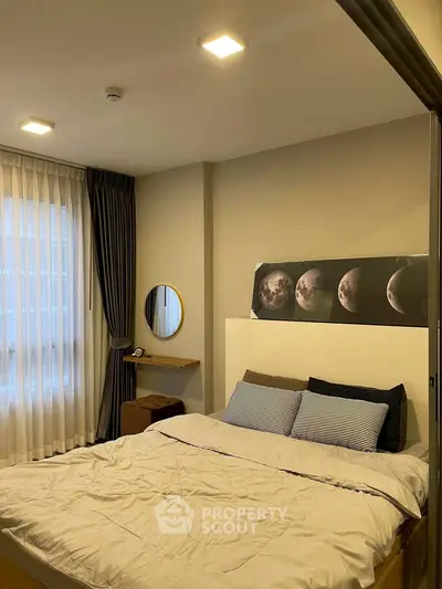 Cozy bedroom with modern decor and moon phase artwork, featuring a comfortable bed and stylish lighting.
