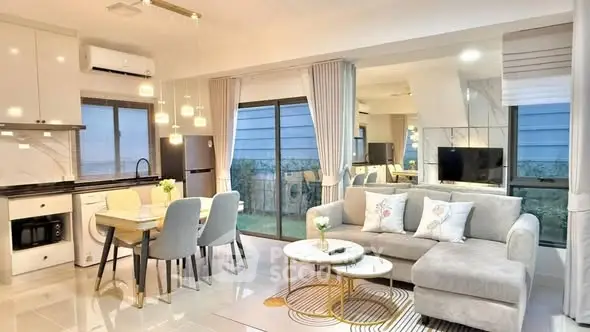 Modern open-plan living room and kitchen with elegant decor and natural light.