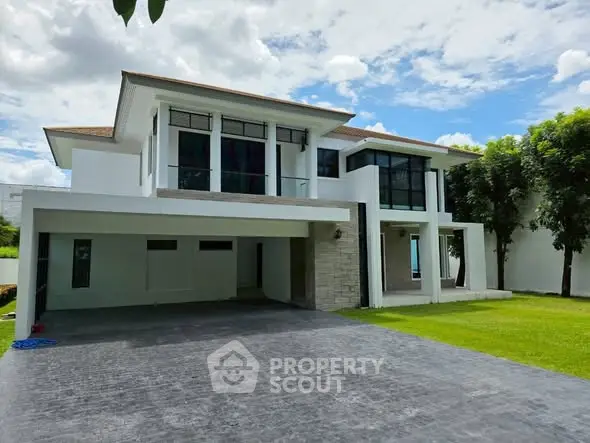 Stunning modern two-story house with spacious driveway and lush green lawn.