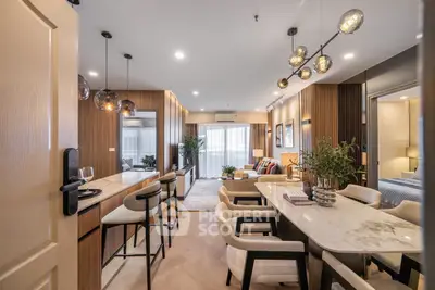 Luxurious modern living room with elegant dining area and stylish lighting fixtures.