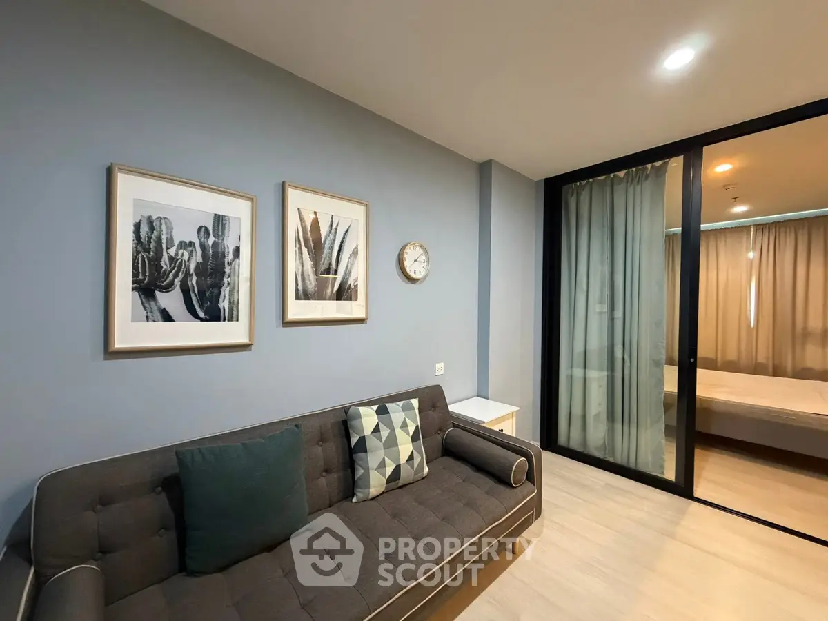 Modern living room with stylish decor and view into cozy bedroom