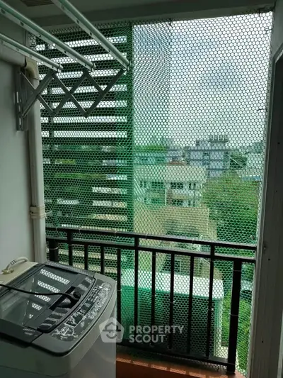 Charming balcony with laundry area and city view, perfect for urban living convenience.