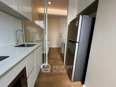 Modern kitchen with sleek design, featuring stainless steel appliances and wooden flooring.