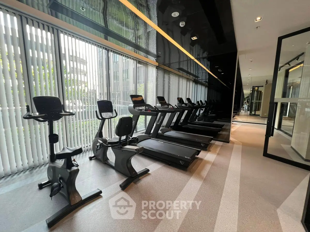 Modern gym with state-of-the-art exercise equipment and large windows for natural light.