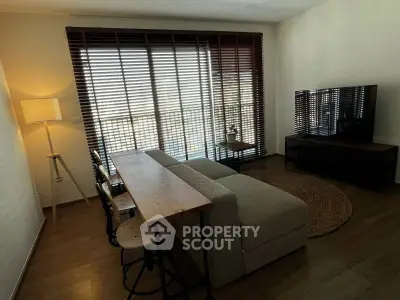 Chic living room with modern decor, large window blinds, cozy sofa, and stylish TV setup.