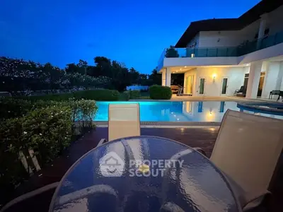 Luxurious villa with private pool and outdoor seating at dusk, perfect for serene living.