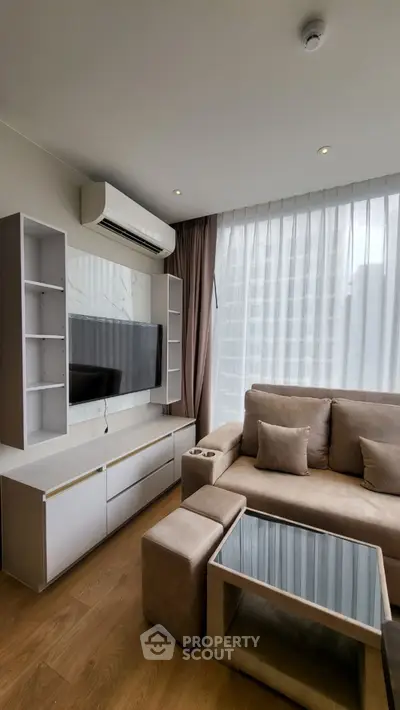 Modern living room with sleek furniture and large window, perfect for urban living.