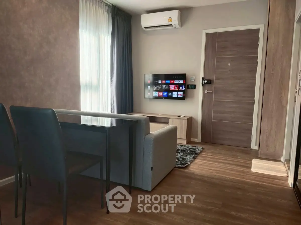 Modern living room with sleek furniture and wall-mounted TV in a cozy apartment.