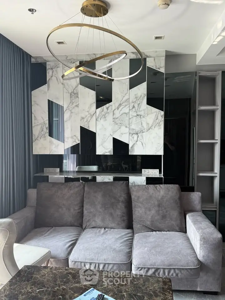 Luxurious modern living room with stylish marble accents and plush gray sofa, perfect for sophisticated urban living.