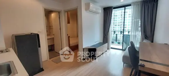 Modern apartment interior with balcony and city view, featuring sleek furniture and bright natural lighting.