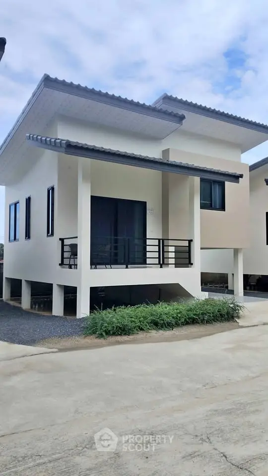 Modern two-story house with sleek design and spacious balcony, perfect for family living in a serene neighborhood.
