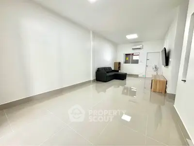 Spacious living room with modern sofa and sleek tiled flooring