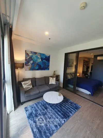 Modern living room with cozy sofa and stylish decor adjacent to a bedroom