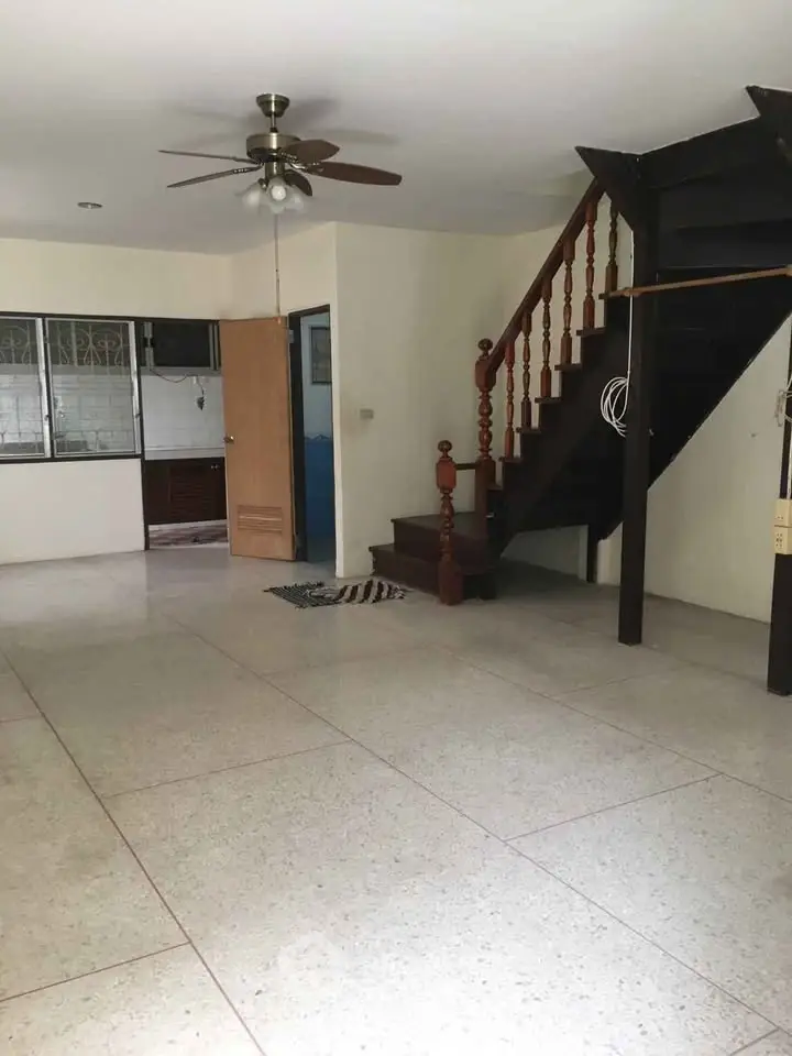 Spacious living room with staircase and ceiling fan in modern home