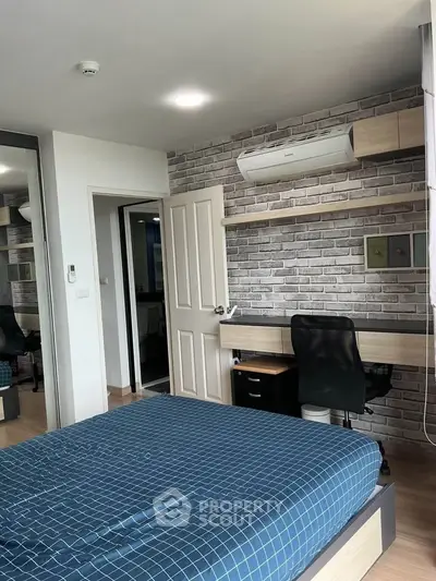 Modern bedroom with stylish brick accent wall and built-in desk, featuring a comfortable bed and air conditioning.