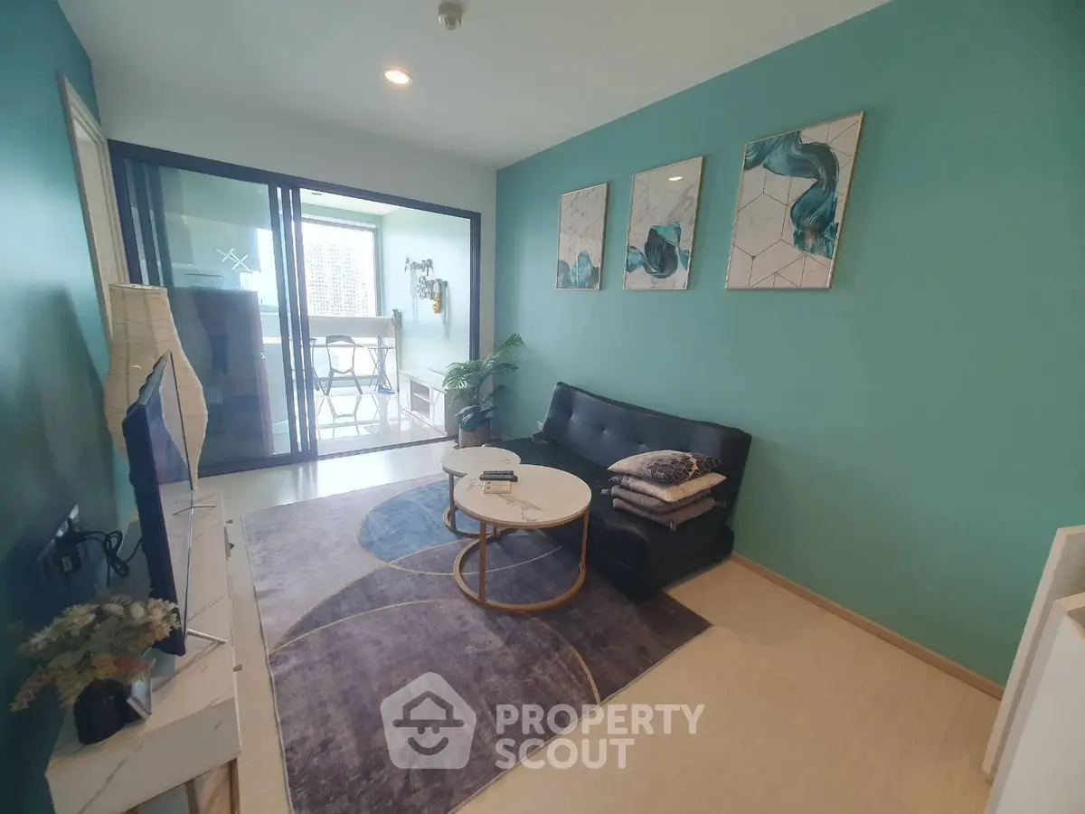Modern living room with teal walls, stylish decor, and balcony access in a chic apartment.