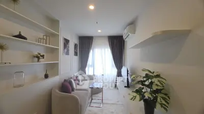 Modern living room with elegant decor, cozy seating, and natural light from large window.
