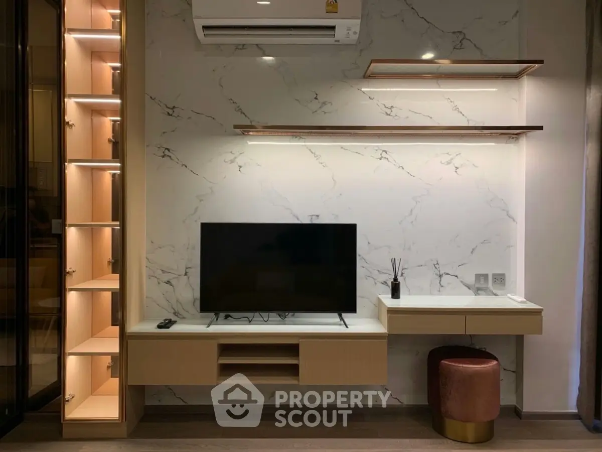 Modern living room with sleek TV unit and stylish shelving, featuring elegant marble wall design.