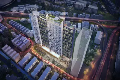 Stunning aerial view of modern high-rise residential building with vibrant cityscape at night.