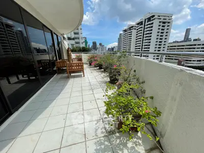 Spacious balcony with city view and lush potted plants, perfect for relaxation and entertaining.