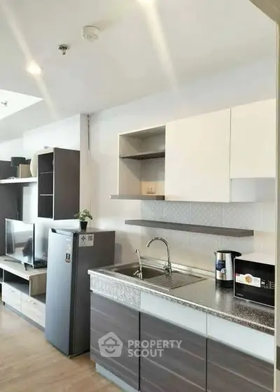 Modern kitchen with sleek cabinetry and stainless steel appliances in a stylish apartment.